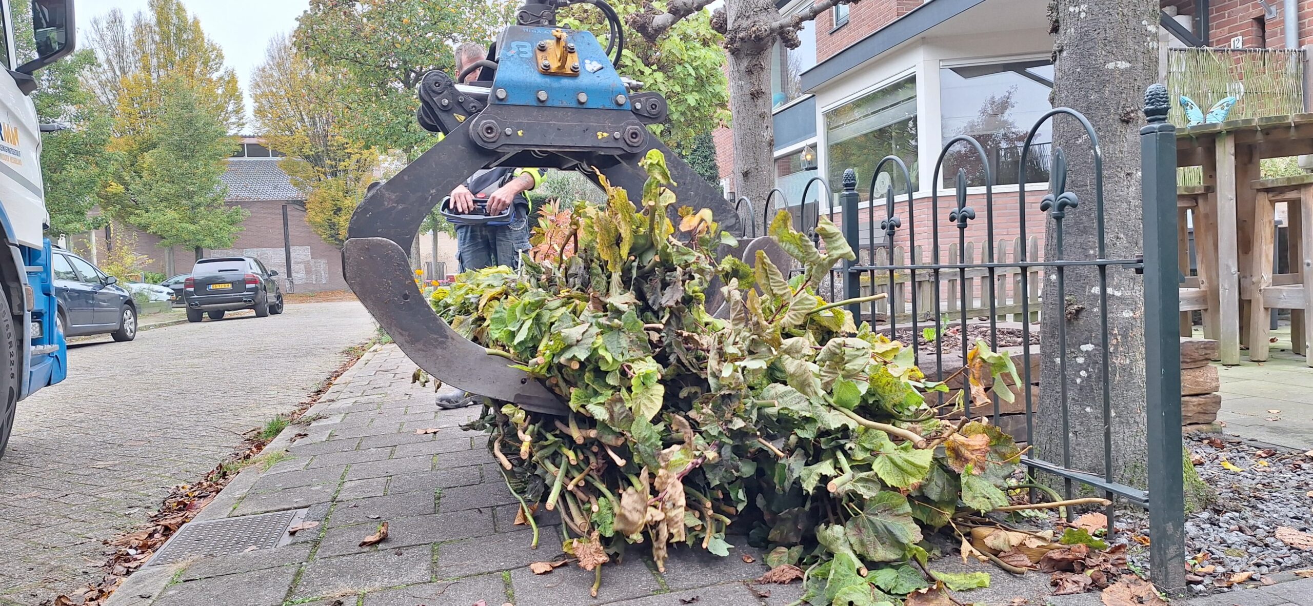 Snoeihout ophalen Grijper zamelt aangeboden snoeihout in